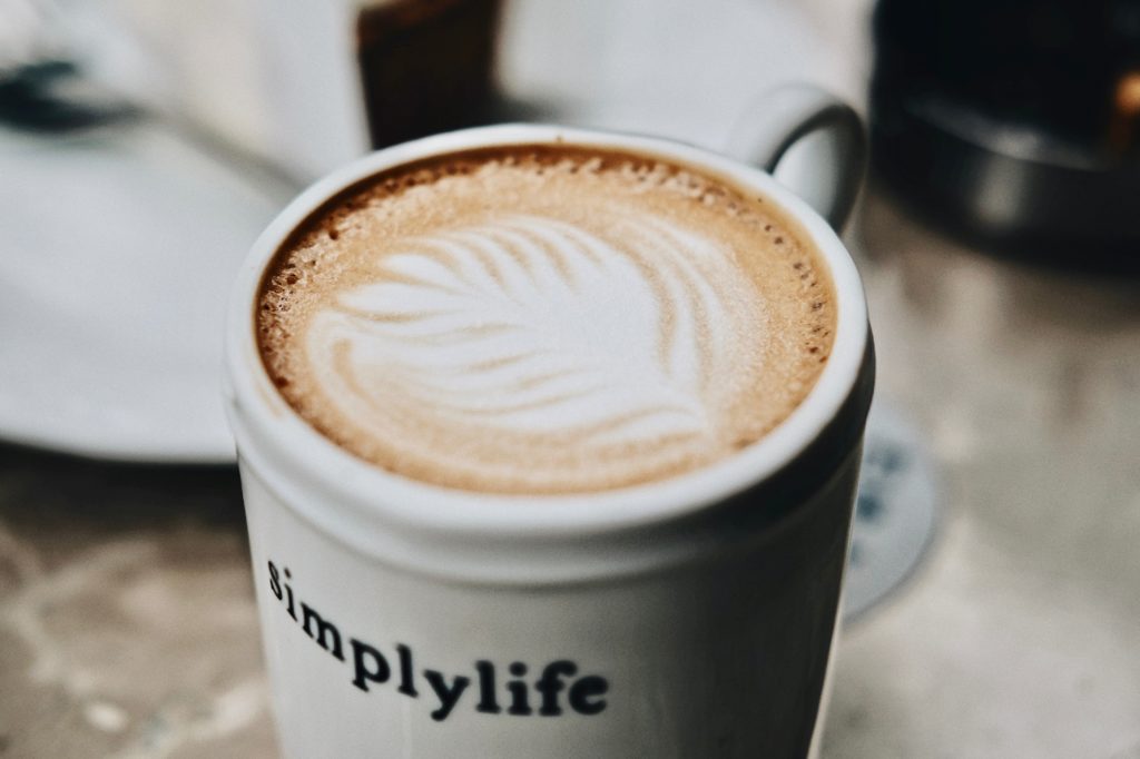 Einfacher Milchkaffee in einer Tasse mit der Aufschrift simplylife