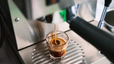 Kaffepadmaschine mit einem Glas Espresso darunter